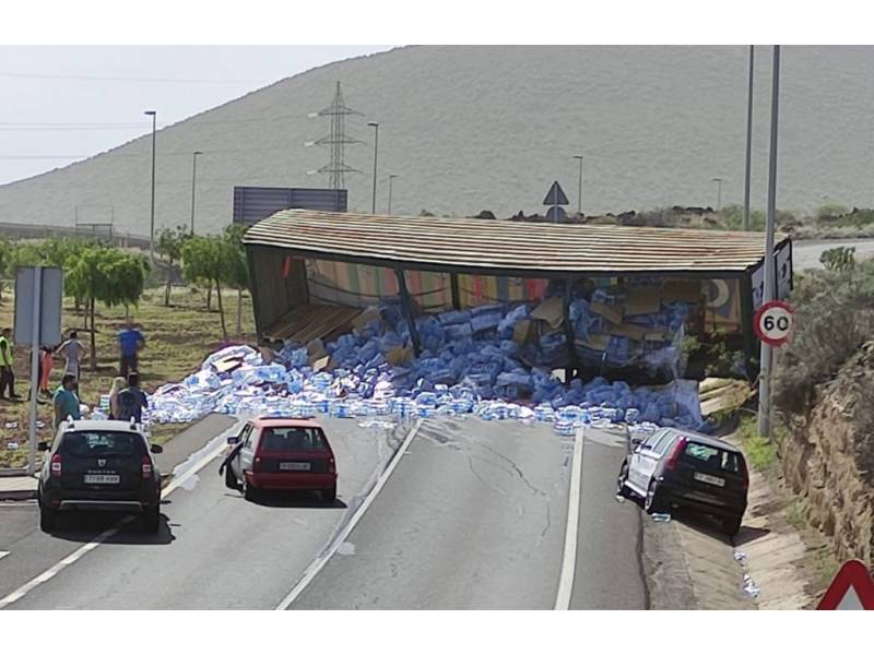 A lorry sheds its load of water bottles and blocks road in Arafo