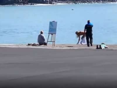 Nude model stopped while posing for a painting in front of the volcano in La Palma