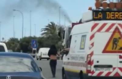 Traffic jams caused by man walking in middle of the motorway with a bunch of flowers