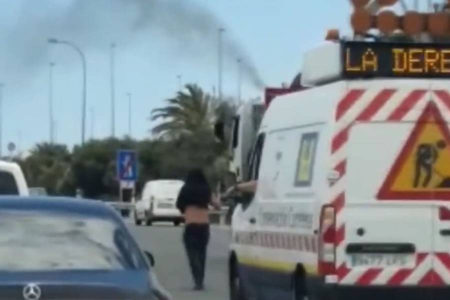 Traffic jams caused by man walking in middle of the motorway with a bunch of flowers