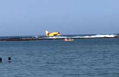 A seaplane surprises bathers and swimmers at Las Canteras beach