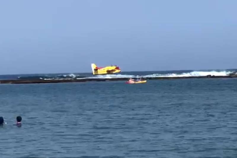 A seaplane surprises bathers and swimmers at Las Canteras beach