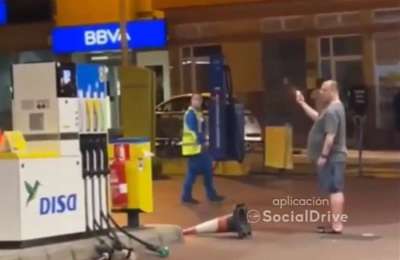 Man pulls out hoses and lights a lighter at a petrol station in the Canary Islands