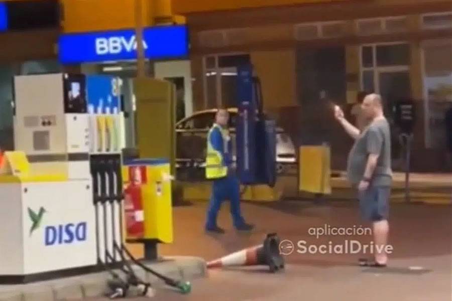 Man pulls out hoses and lights a lighter at a petrol station in the Canary Islands