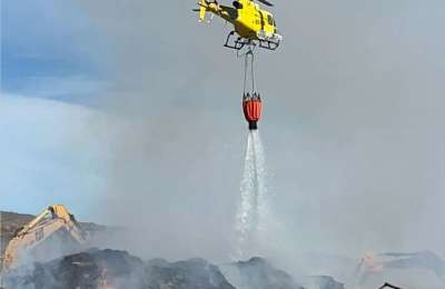 Firefighters use diggers and helicopters to combat the compost plant fire in Tenerife