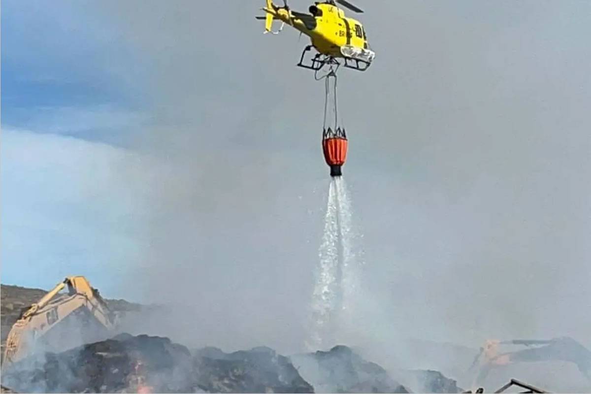 Firefighters use diggers and helicopters to combat the compost plant fire in Tenerife